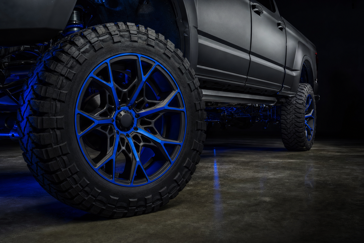 Custom two-tone forged wheels in matte black with electric blue accents